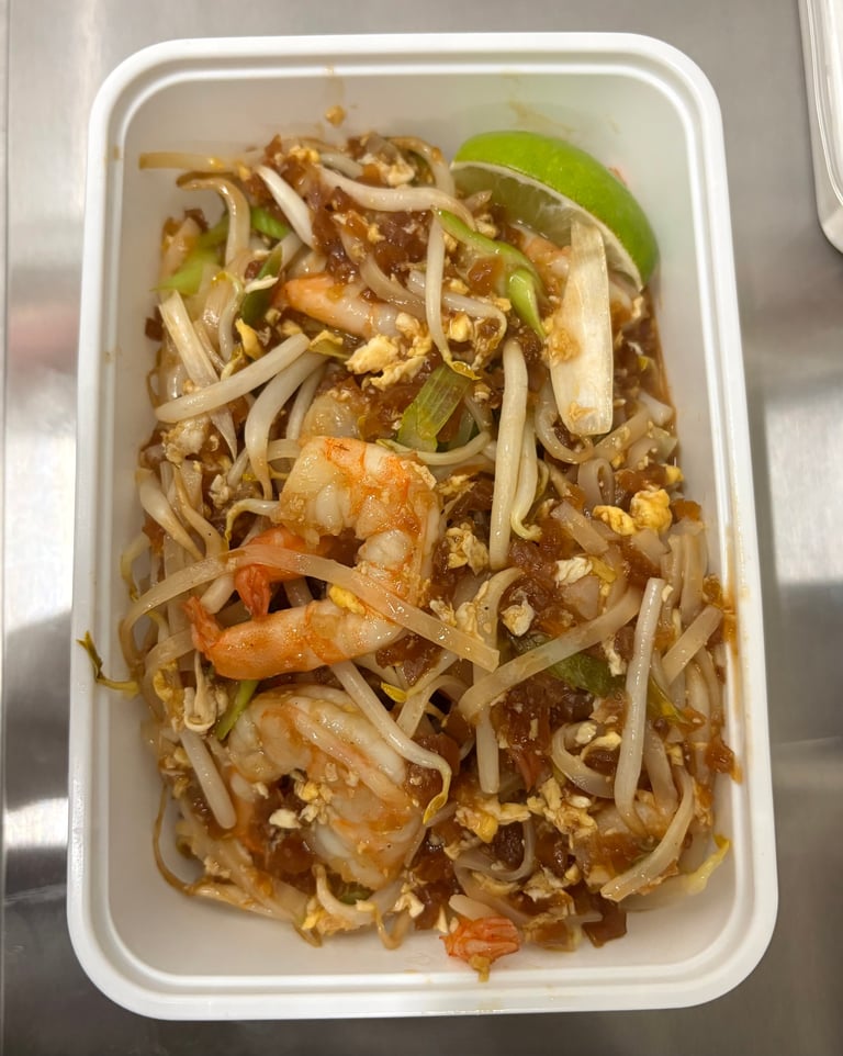 Pad Thai with shrimp and peanuts in a white takeout container